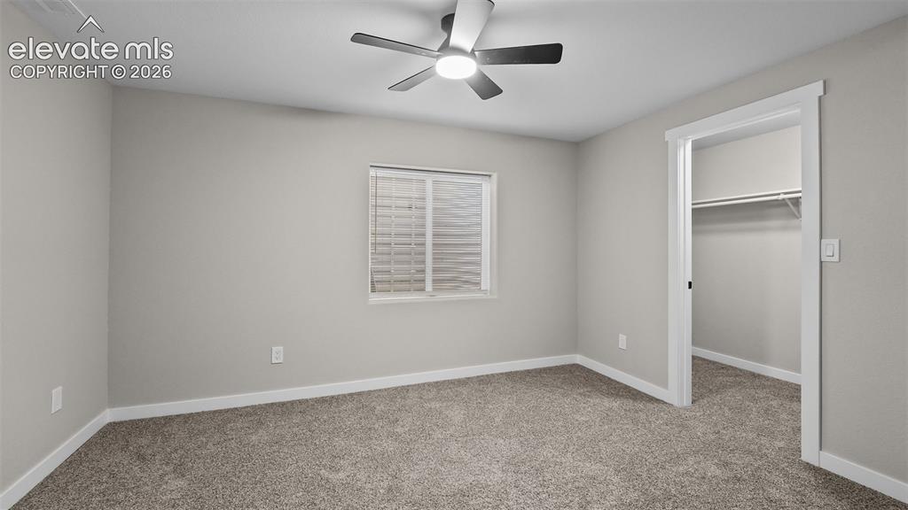 Image 31 of 47: Gray carpeting, white trim, recessed window with blinds, and ceiling fan wi