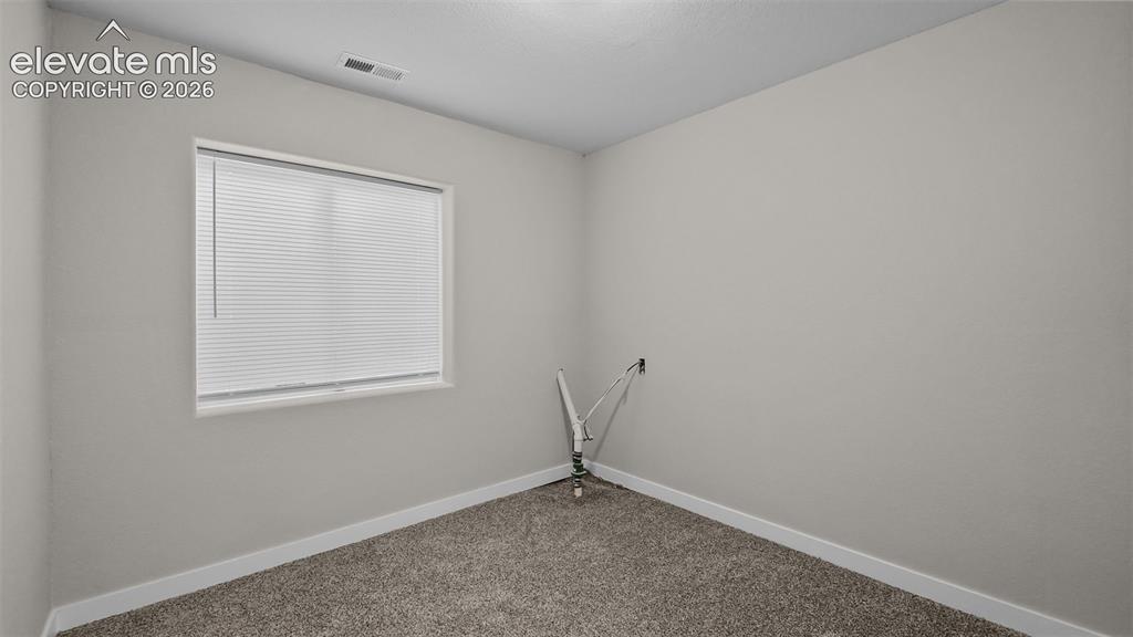 Image 32 of 47: Window with blinds, wall-to-wall carpeting, and neutral wall tones