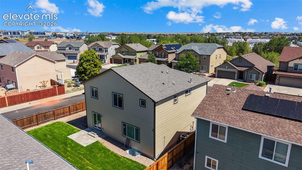 Image 36 of 47: Two-story residence with a pitched roof, exterior siding, and a fenced back