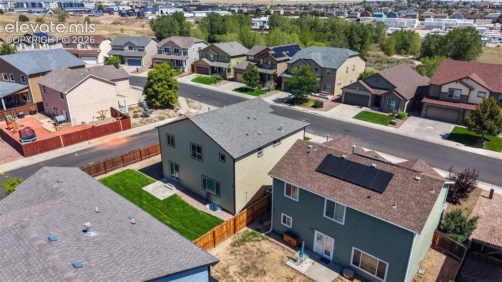 Image 37 of 47: Residential neighborhood with mature trees, two-story homes, and visible ro