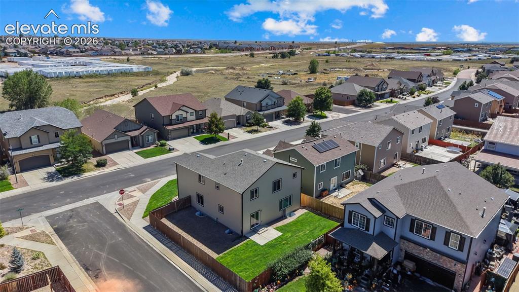 Image 42 of 47: Residential street with uniform housing styles and varied exterior finishes