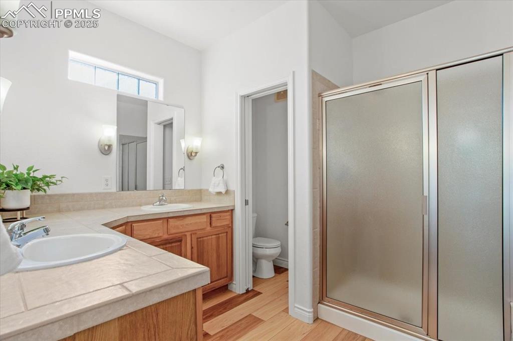Image 14 of 31: Full bath featuring a stall shower, double vanity, and light wood finished