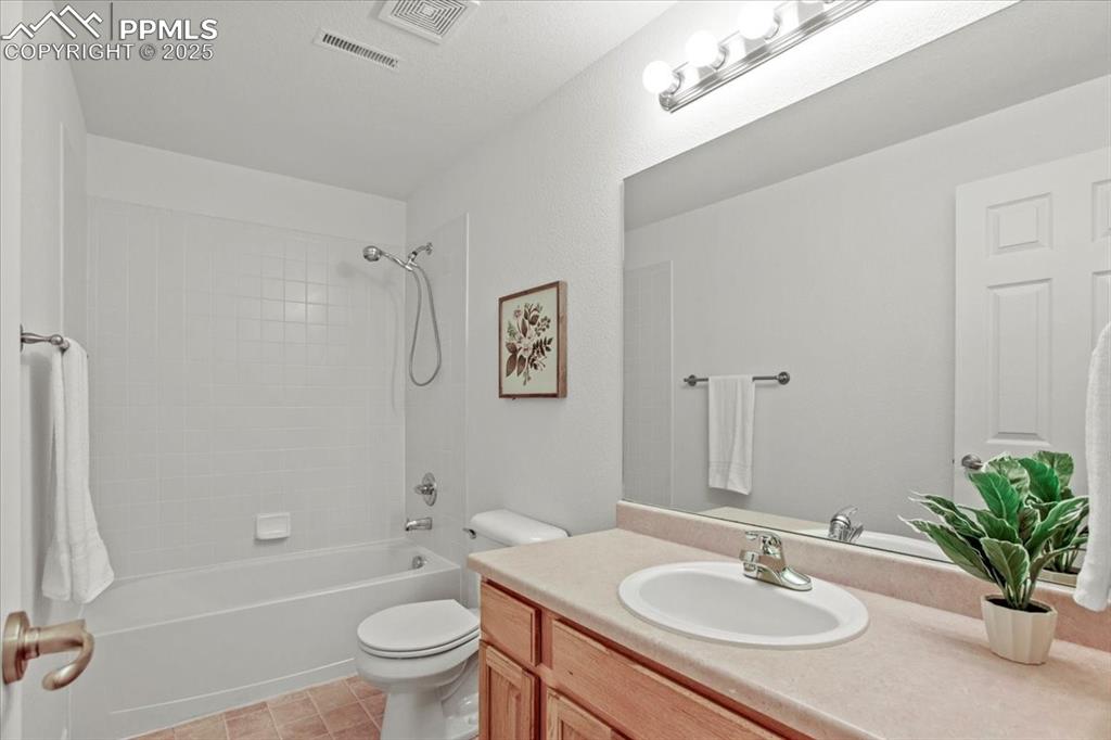 Image 20 of 31: Bathroom with shower / bathtub combination, vanity, and light tile patterne