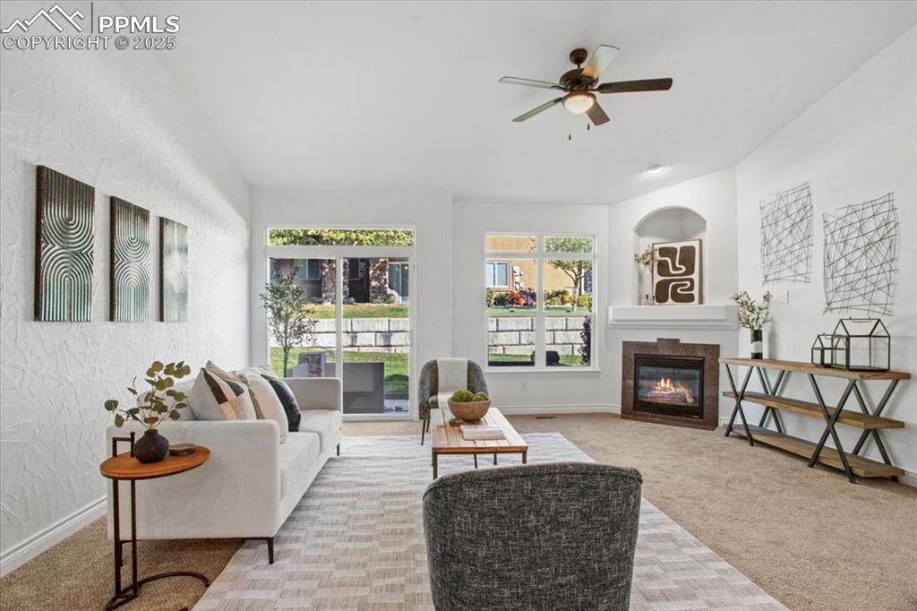 Image 9 of 31: Carpeted living room with a textured wall, a tile fireplace, and a ceiling