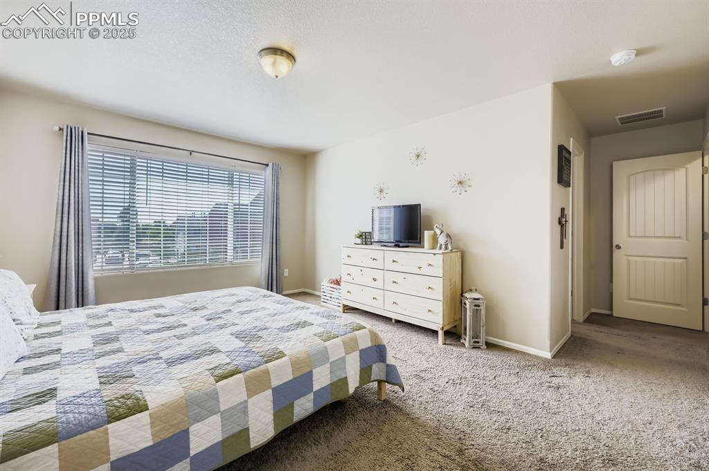Image 16 of 27: Carpeted bedroom with baseboards