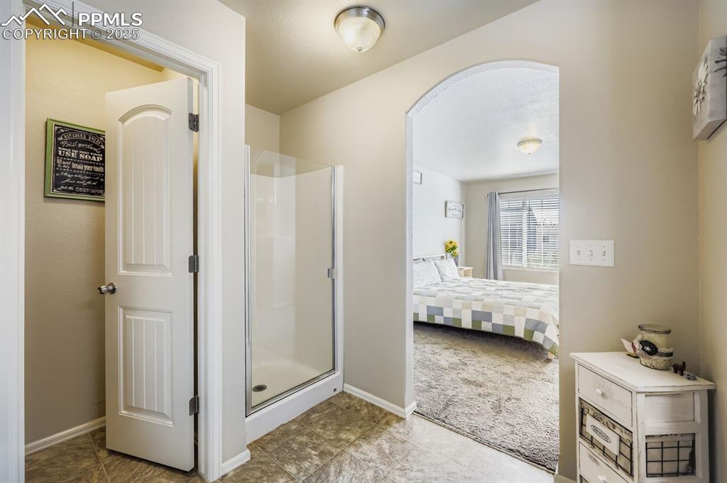 Image 18 of 27: Full bath with a shower stall and ensuite bath