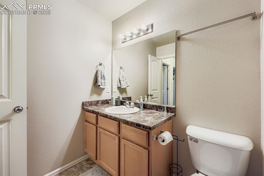 Image 25 of 27: Bathroom with a textured wall and vanity