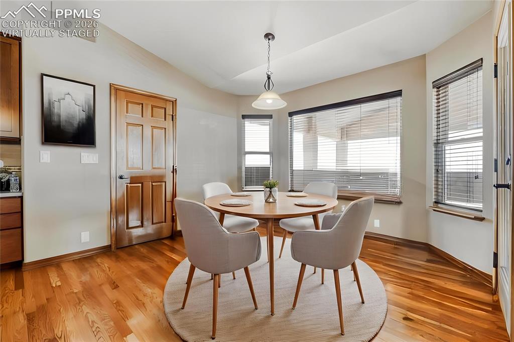 Image 10 of 31: Virtually Staged - Dining area featuring wood-finish flooring, multiple win
