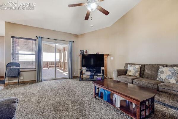 Image 11 of 31: Spacious room featuring vaulted ceilings, ceiling fan with integrated light