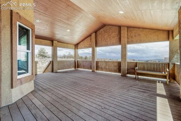 Image 12 of 31: Expansive covered deck featuring wood-finish flooring, recessed lighting, a