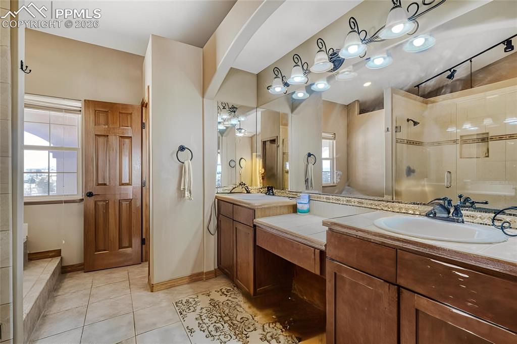 Image 17 of 31: Bathroom featuring a dual vanity with integrated sinks, tile countertops, a