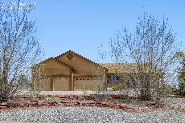 Image 2 of 31: Stucco exterior residence featuring a prominent two-car garage with individ