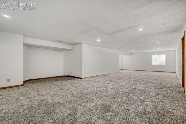 Image 21 of 31: Expansive interior space featuring light gray textured carpeting, white pai