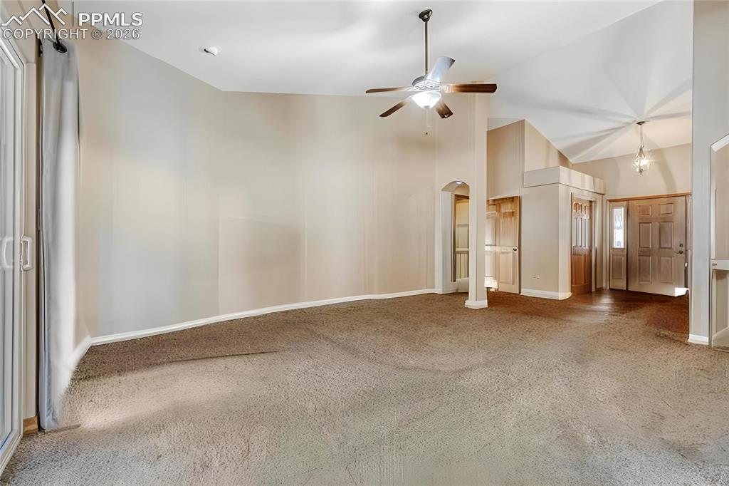 Image 5 of 31: Spacious living area featuring vaulted ceilings, ceiling fan with integrate