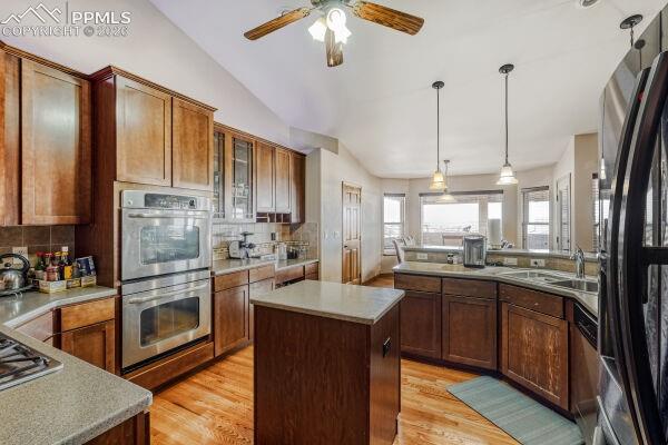Image 8 of 31: Kitchen featuring wood-finish cabinetry, stainless steel double wall ovens,