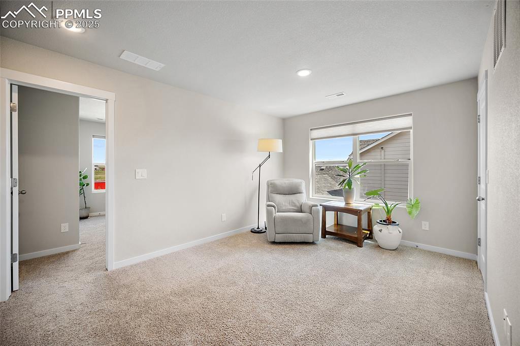 Image 22 of 40: Loft reading corner and flex space with view to second bedroom