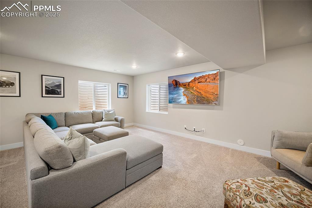 Image 28 of 40: Basement theater room complete with 76" wall mounted flatscreen with concea