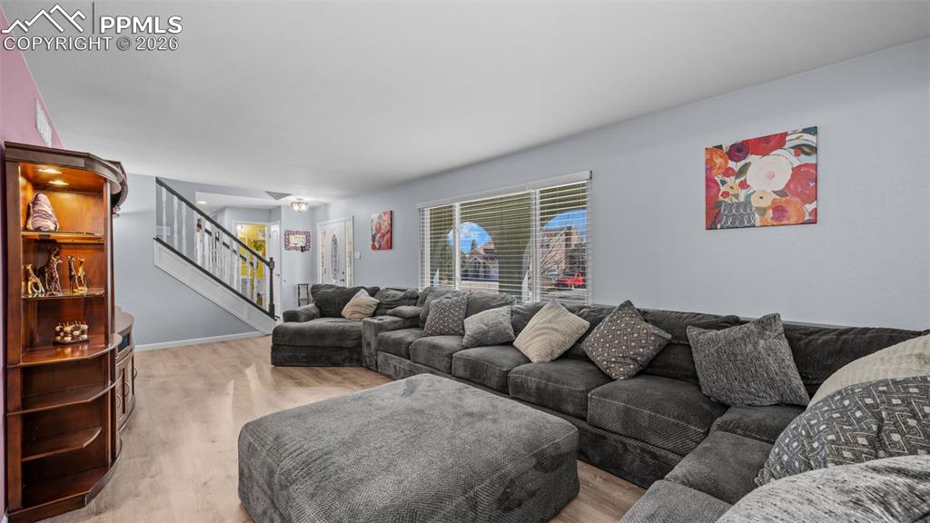 Image 11 of 44: Living area with stairs and light wood-style floors