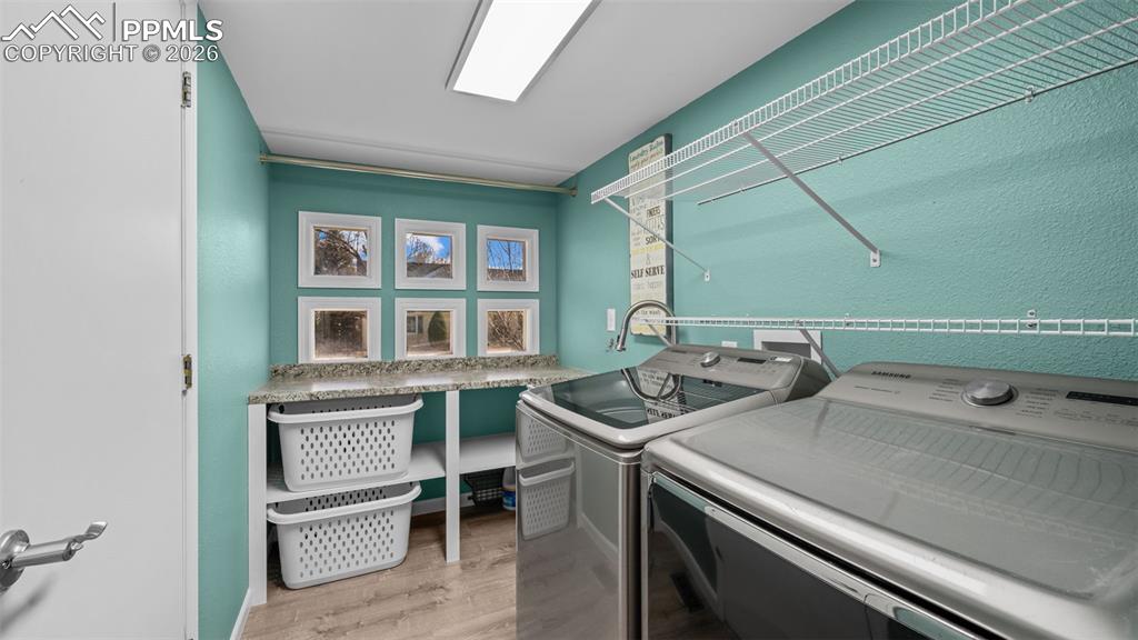 Image 13 of 44: Laundry room featuring light wood-type flooring and independent washer and 