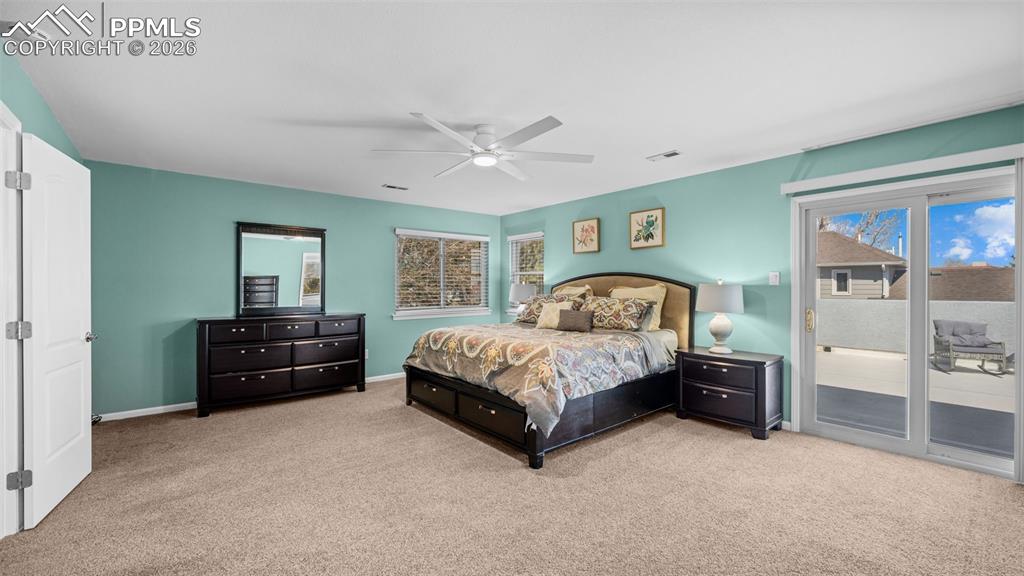 Image 14 of 44: Bedroom featuring access to exterior, light colored carpet, and ceiling fan