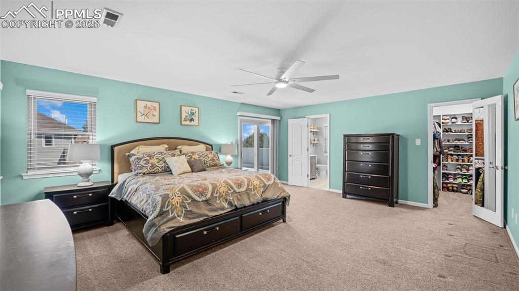 Image 15 of 44: Carpeted bedroom with a spacious closet, ensuite bathroom, and ceiling fan