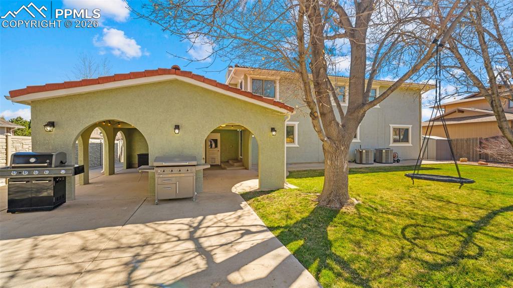 Image 28 of 44: Rear view of property featuring stucco siding, a patio, and a tiled roof