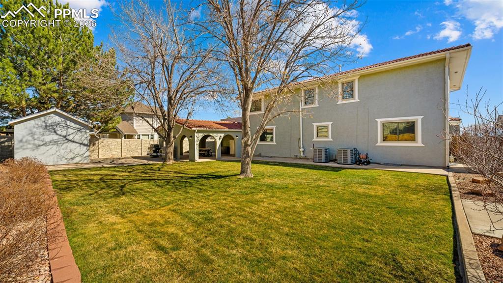 Image 29 of 44: Back of house with a fenced backyard, a patio, and stucco siding