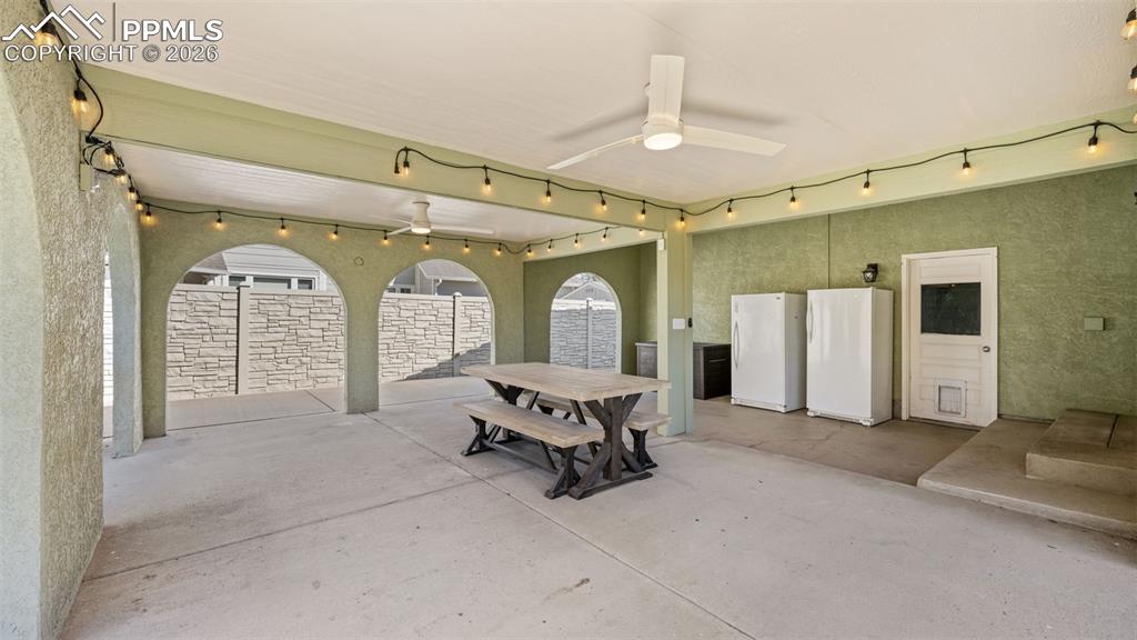 Image 31 of 44: View of patio with ceiling fan and outdoor dining area