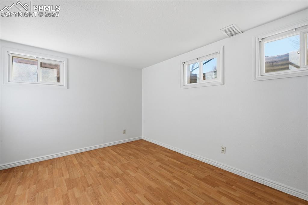 Image 21 of 32: Large bedroom with plank flooring