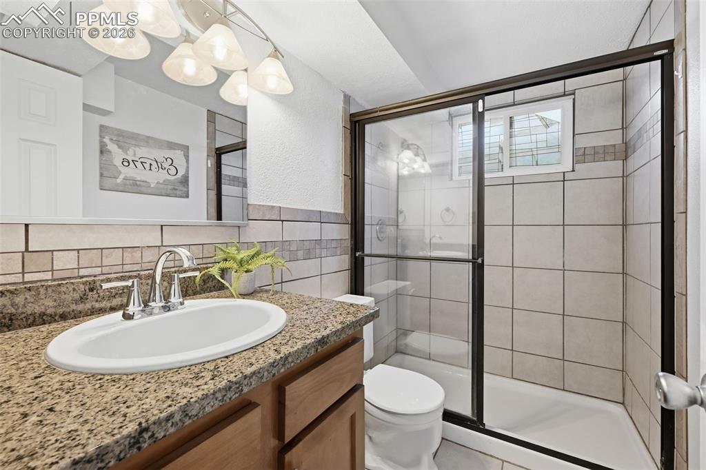 Image 23 of 32: Bright basement bath with window and walk-in shower