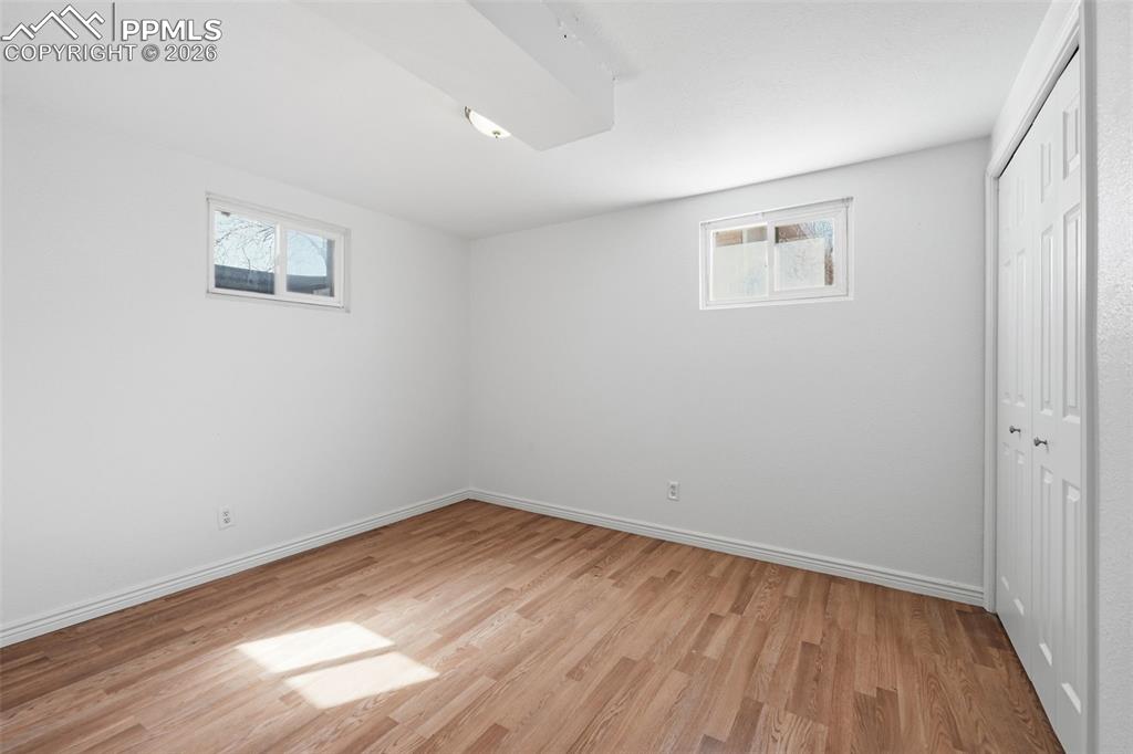 Image 24 of 32: Spacious basement bedroom with plank flooring