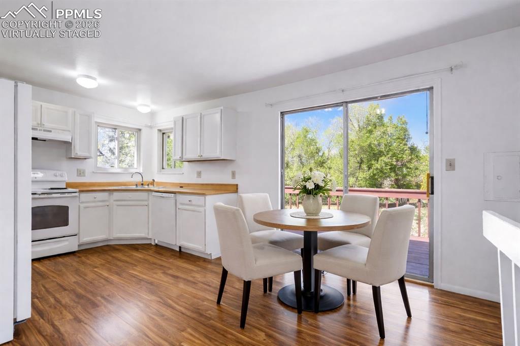 Image 10 of 50: Virtually Staged - Bright kitchen with white cabinetry, wood-look counterto