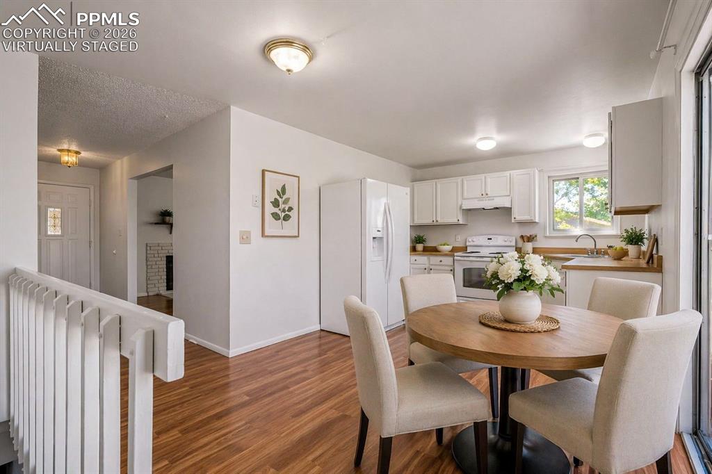 Image 12 of 50: Virtually Staged - The property features wood flooring, a kitchen with whit