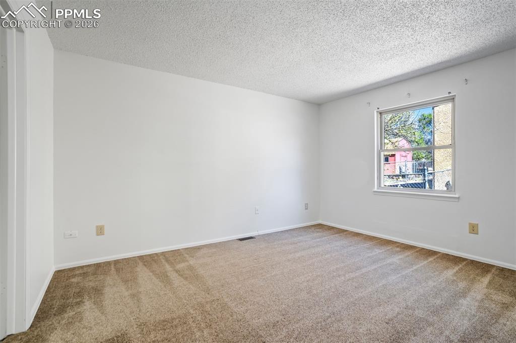 Image 20 of 50: This room features neutral-toned carpet and white walls, creating a versati