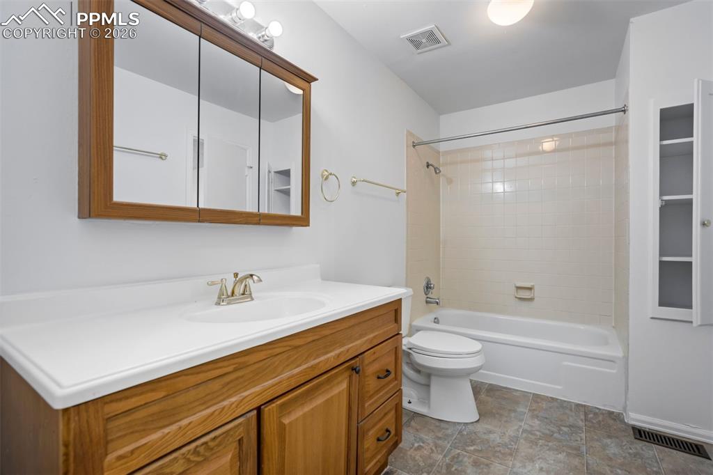 Image 22 of 50: This bathroom features a wood vanity with a white countertop and an integra