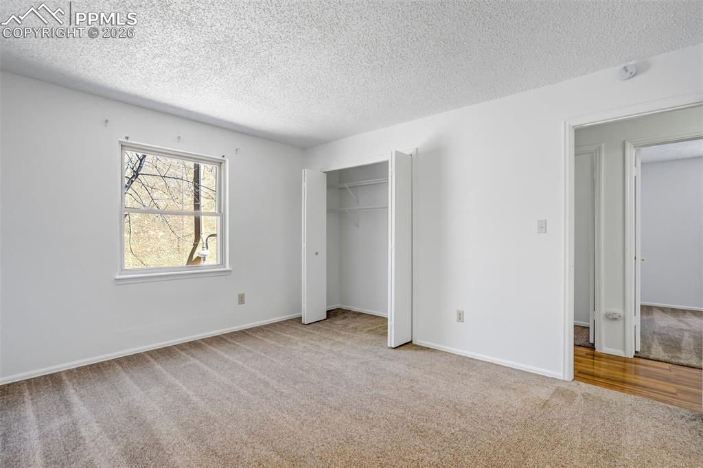 Image 27 of 50: This room features light brown carpet and white walls, creating a neutral c
