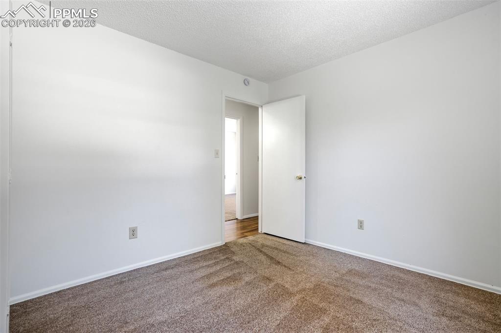 Image 31 of 50: This room features plush brown carpeting, white walls, and a white ceiling