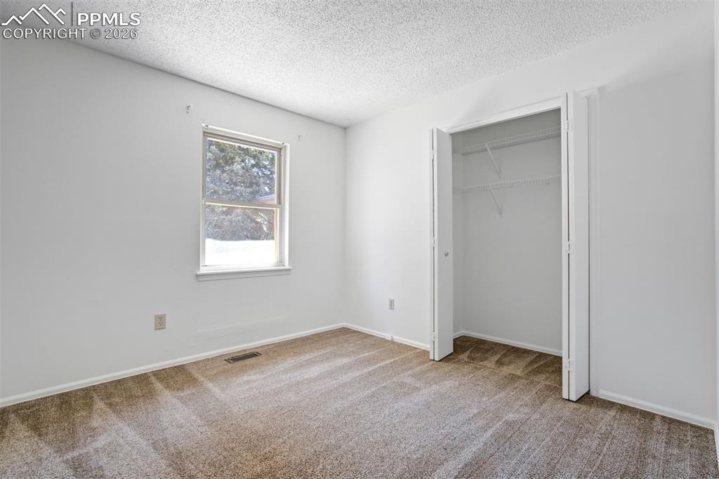 Image 33 of 50: This room features a window providing natural light, a neutral carpet, and 