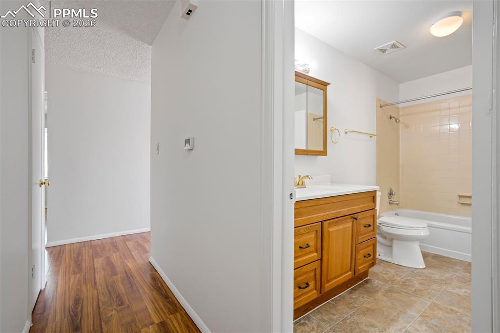 Image 35 of 50: Well-maintained bathroom featuring a wooden vanity with a white countertop,