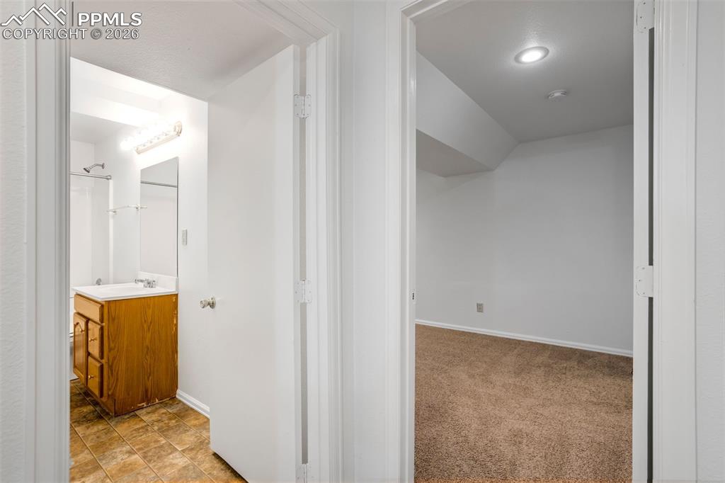 Image 41 of 50: The property features a bathroom with a wood vanity, white sink, and tiled 