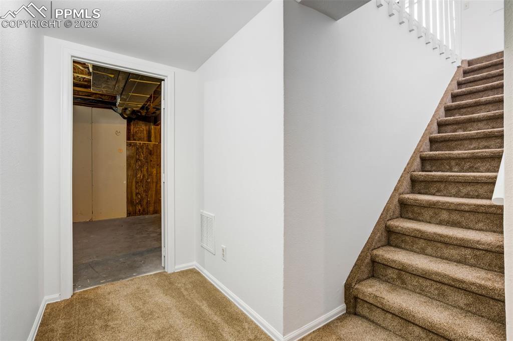 Image 44 of 50: Carpeted stairs with white balusters