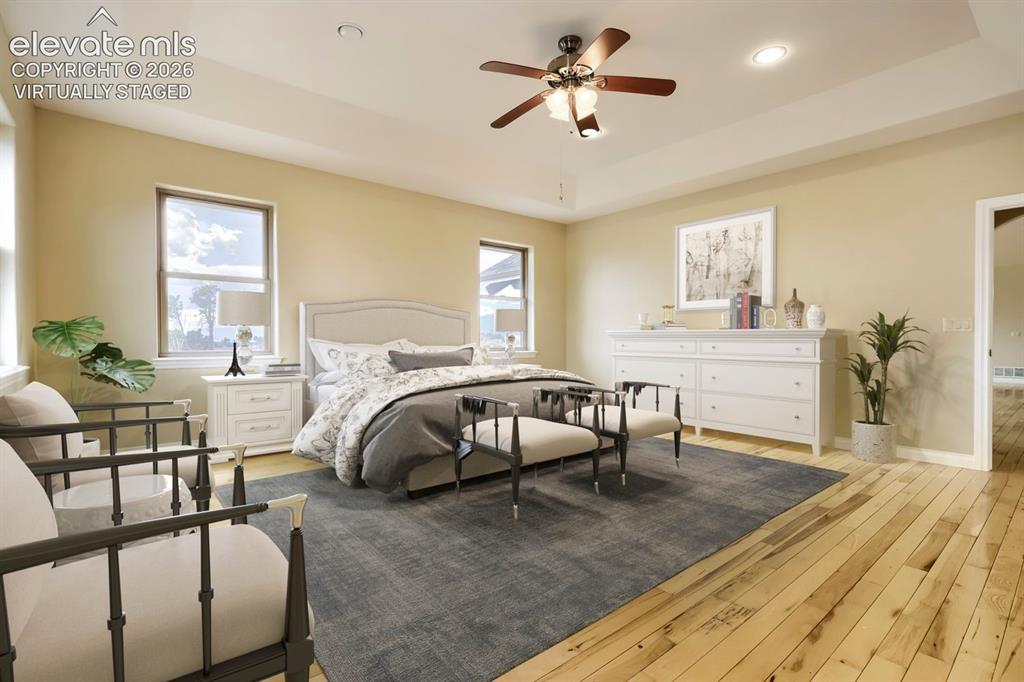 Image 21 of 47: virtually staged - This spacious primary bedroom boasts stunning Pikes Peak