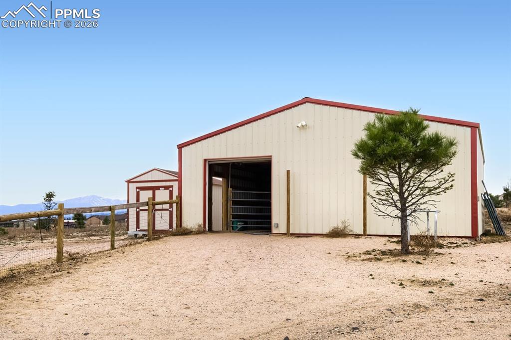 Image 38 of 48: Large barn with two stalls and a large work station/tack room.