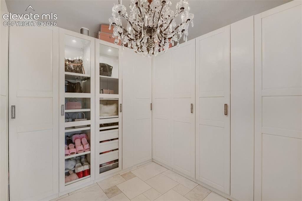 Image 28 of 50: Custom cabinetry, enclosed hanging clothes with an excellent display case