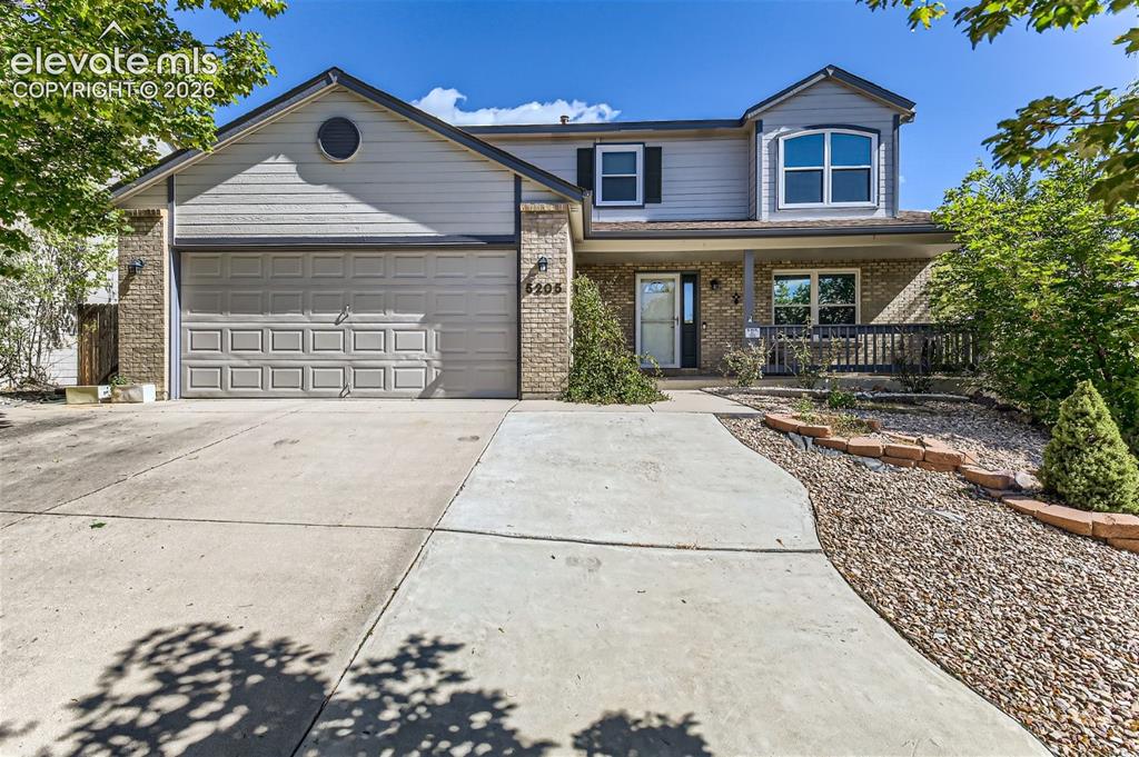Caption: Two-story residence featuring a covered front porch, an attached two-car garage, and a concrete driv