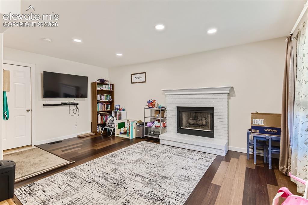 Image 14 of 49: Living area featuring wood-finish flooring, recessed lighting, and a white 