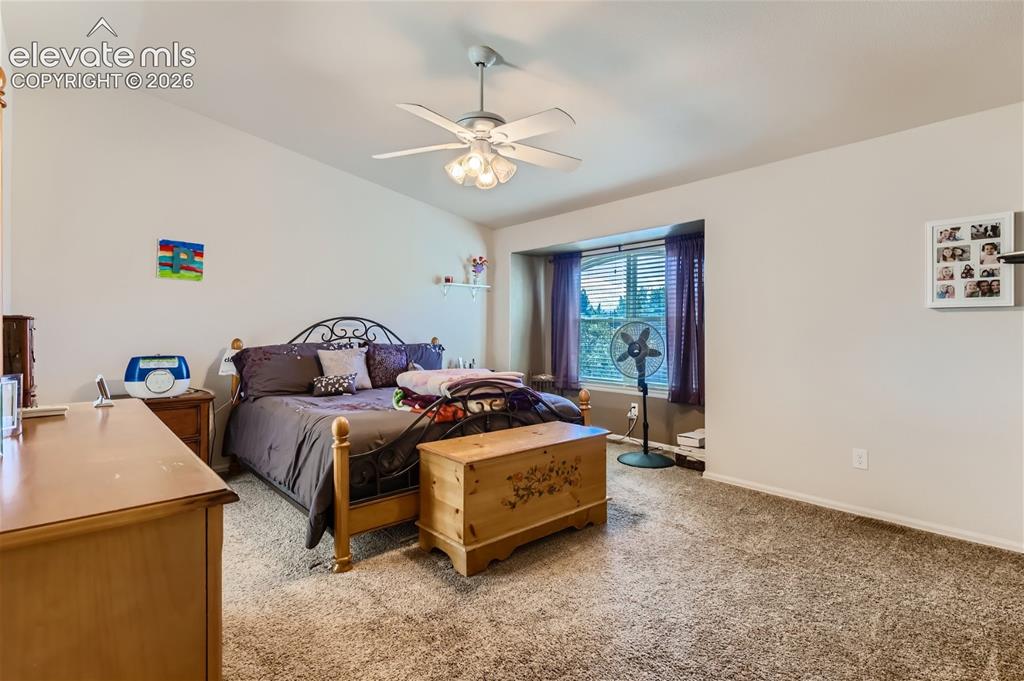 Image 18 of 49: Carpeted flooring throughout, with a ceiling fan light fixture and sloped c
