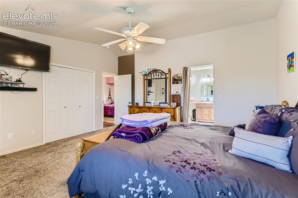 Image 20 of 49: Vaulted ceiling with a ceiling fan light fixture, carpet flooring, a wall-m