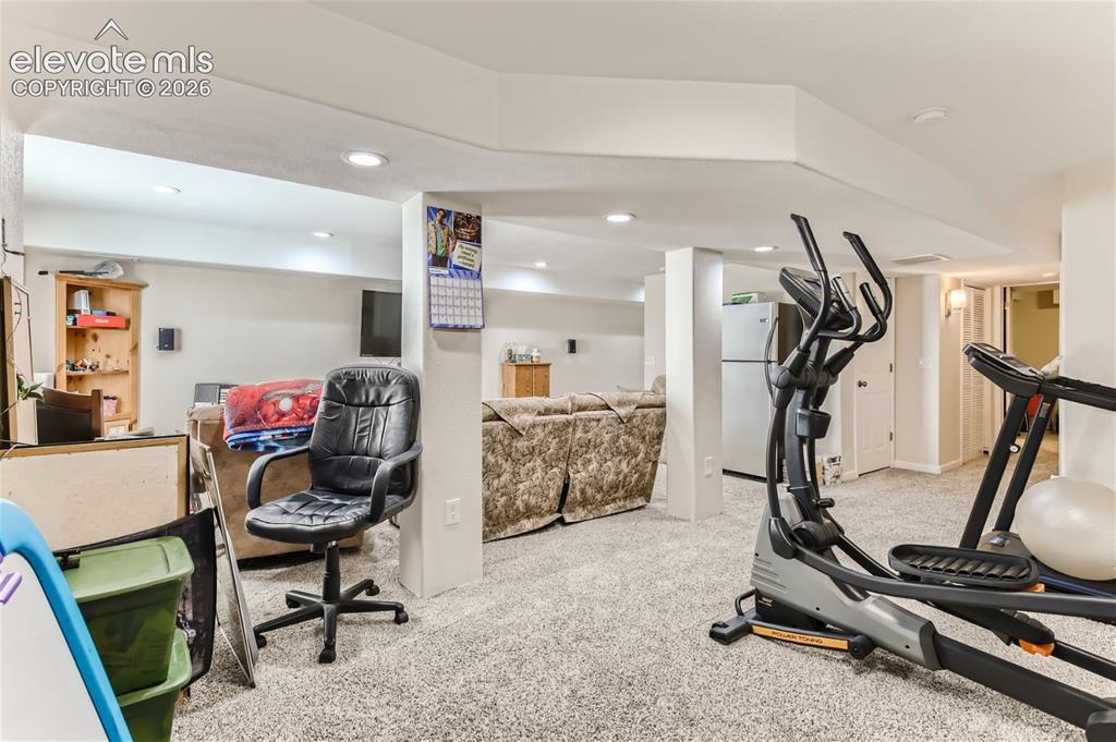 Image 29 of 49: Carpeted lower level featuring recessed lighting, white walls, and a freest