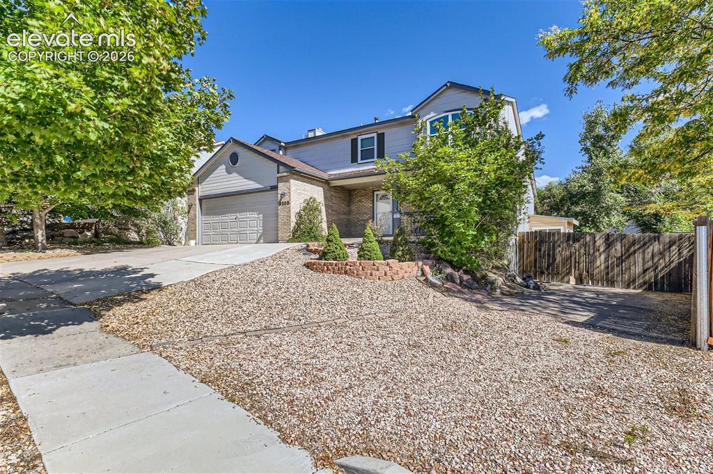 Image 3 of 49: Two-story residence featuring a bay window, attached garage, and stone faca